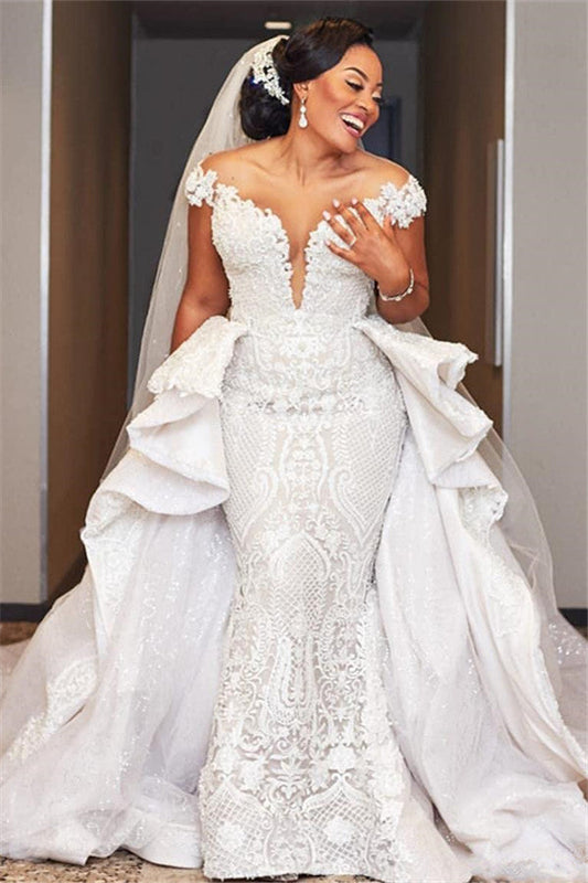 Vestido de novia largo estilo sirena con mangas cortas y sobrefalda con volantes