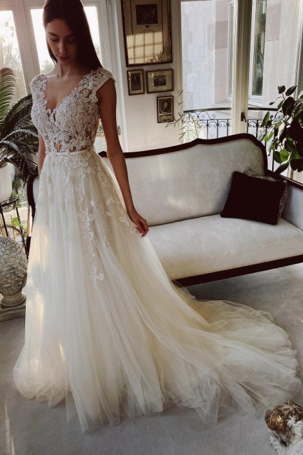 Vestido de novia de encaje color marfil, corte A, largo hasta el suelo, escote en V y jardín.