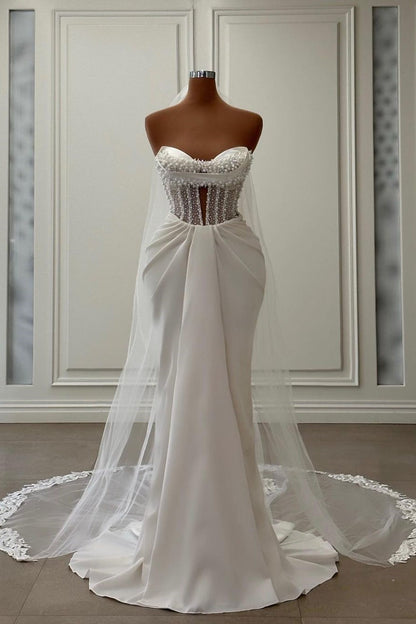 Vestido de novia largo de satén color marfil con escote sirena, sin mangas y perlas