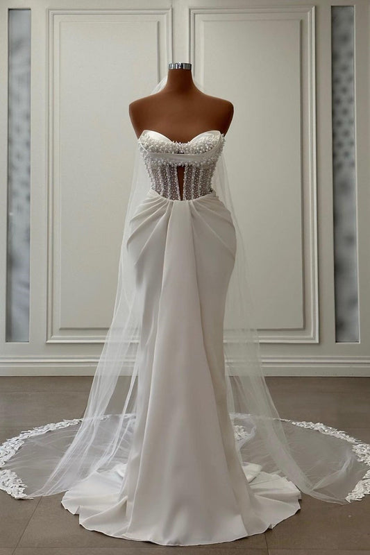 Vestido de novia largo de satén color marfil con escote sirena, sin mangas y perlas