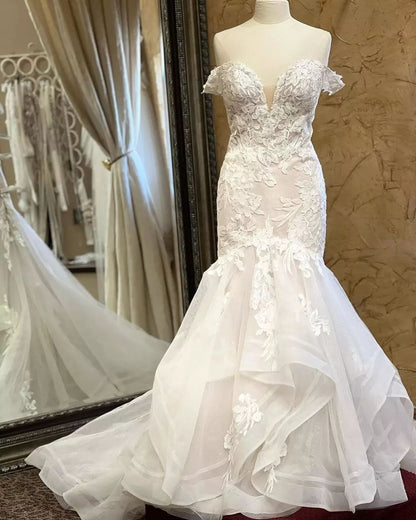 Encantador vestido de novia blanco sin mangas con escote en V y encaje de sirena con apliques