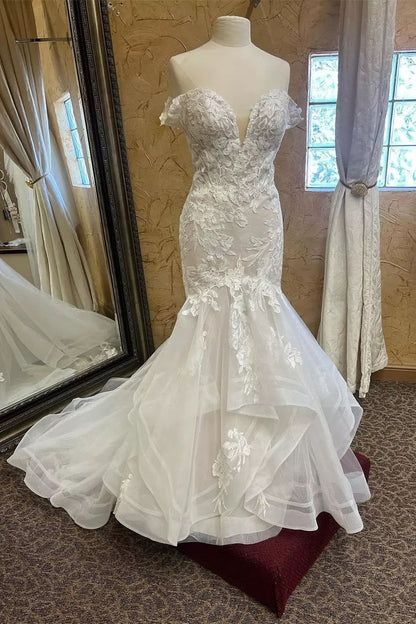 Encantador vestido de novia blanco sin mangas con escote en V y encaje de sirena con apliques