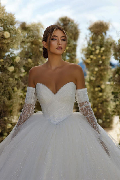 Vestido de novia encantador de corte A con escote en V, sin mangas y brillo, con cola