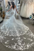 Vestidos de novia color marfil sin mangas con tirantes finos, encaje y apliques en la cola.