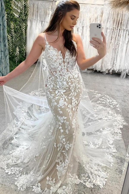 Vestidos de novia color marfil sin mangas con tirantes finos, encaje y apliques en la cola.