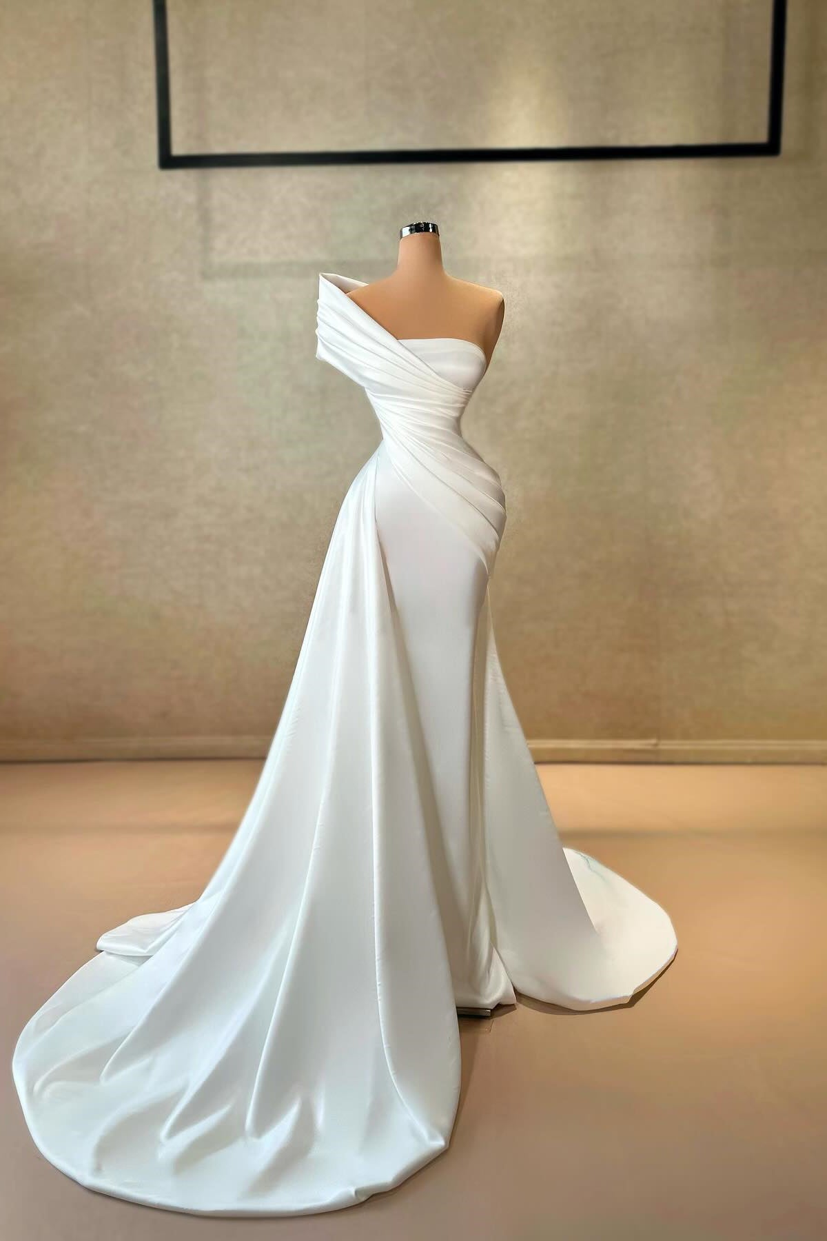 Elegante vestido de fiesta largo blanco de satén con volantes, cola y un hombro descubierto