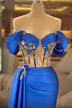 Elegante vestido de fiesta azul sin mangas con hombros descubiertos y cuentas con abertura