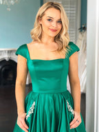Elegante vestido de graduación largo de satén con mangas casquillo y corte A con bolsillos