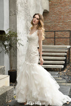 Elegante vestido de novia de sirena con escote en V y apliques de encaje de tul.