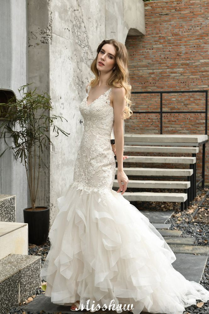 Elegante vestido de novia de sirena con escote en V y apliques de encaje de tul.
