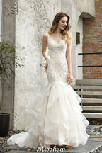 Elegante vestido de novia de sirena con escote en V y apliques de encaje de tul.