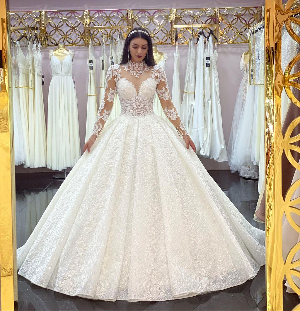 Wunderschönes langes Prinzessinnen-Brautkleid mit hohem Halsausschnitt, Spitzenapplikationen und Ärmeln