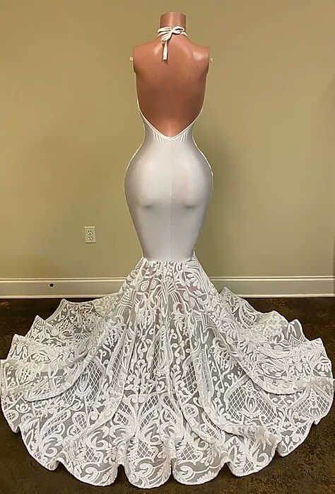 Hermoso vestido de fiesta blanco con escote en V y sin mangas, corte sirena, con encaje y flores en la parte inferior.