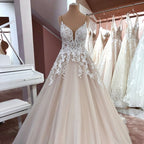 Vestido de novia largo de tul con escote en V, tirantes finos, espalda descubierta y apliques de encaje