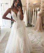Vestido de novia estilo sirena con escote en V y tirantes finos y cola desmontable.