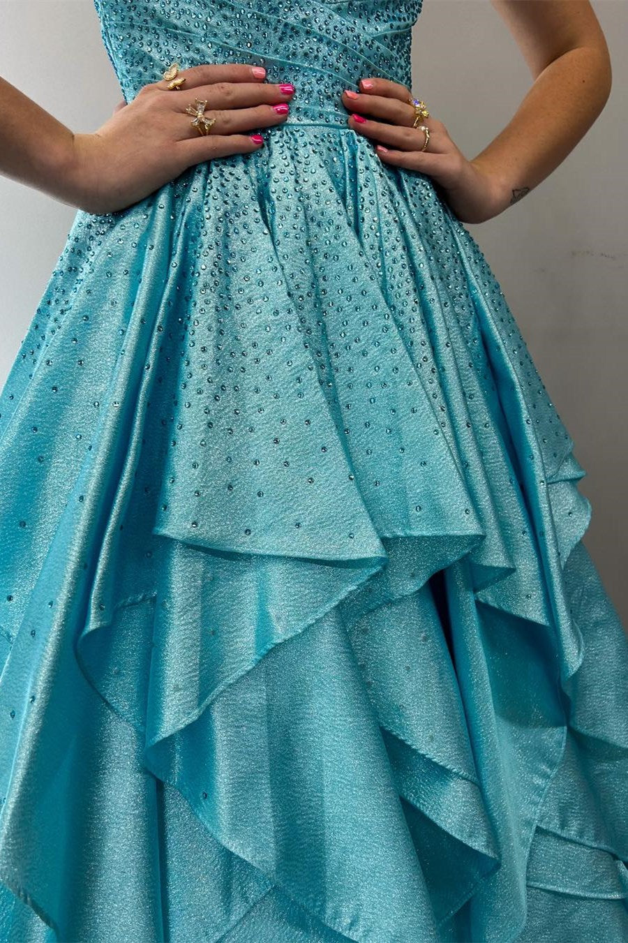 Vestido de fiesta largo con volantes multicapa en color azul agua con piedras calientes de nácar