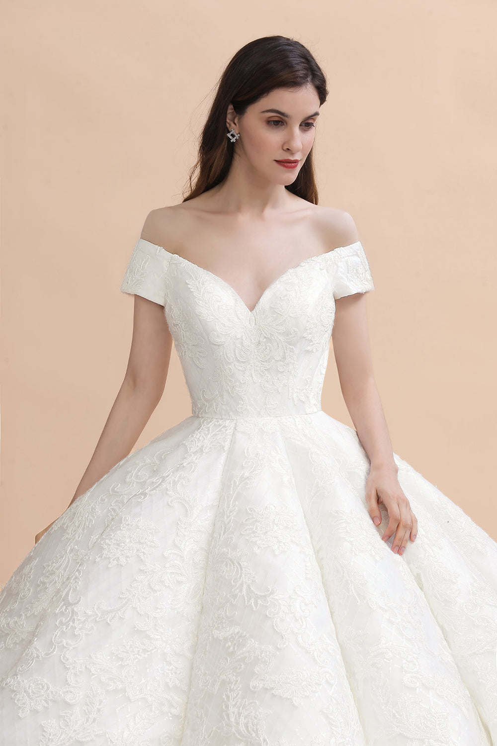 Vestido de novia largo hasta el suelo con hombros descubiertos y apliques de encaje y cola capilla