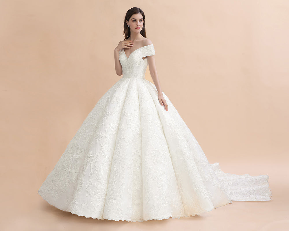 Vestido de novia largo hasta el suelo con hombros descubiertos y apliques de encaje y cola capilla