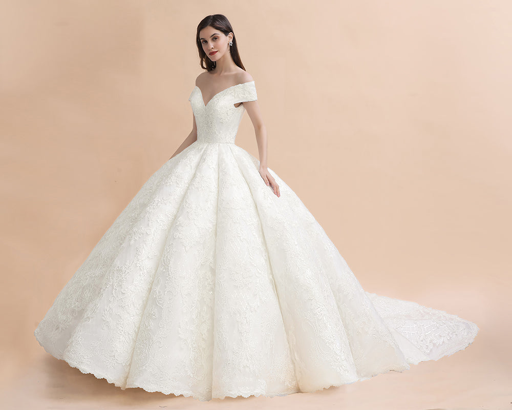 Vestido de novia largo hasta el suelo con hombros descubiertos y apliques de encaje y cola capilla
