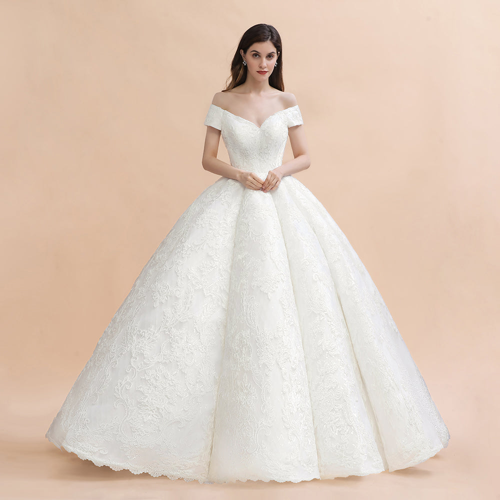 Vestido de novia largo hasta el suelo con hombros descubiertos y apliques de encaje y cola capilla