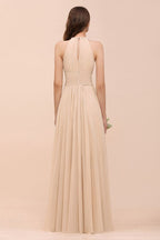 Vestido de dama de honor largo, ajustado, color champán y con cuello halter sencillo