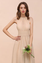Vestido de dama de honor largo, ajustado, color champán y con cuello halter sencillo