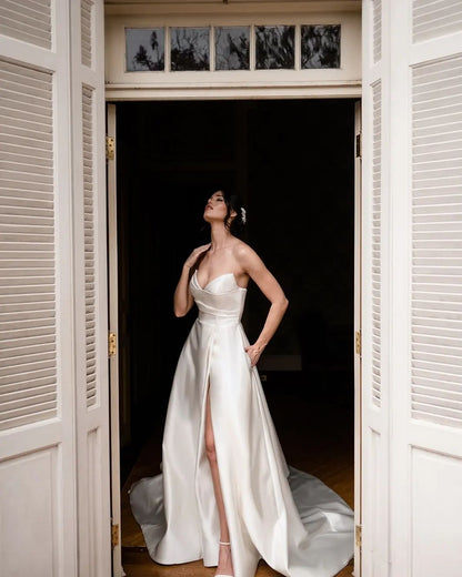 Schlichtes langes elfenbeinfarbenes ärmelloses A-Linien-Brautkleid mit V-Ausschnitt und Schlitz