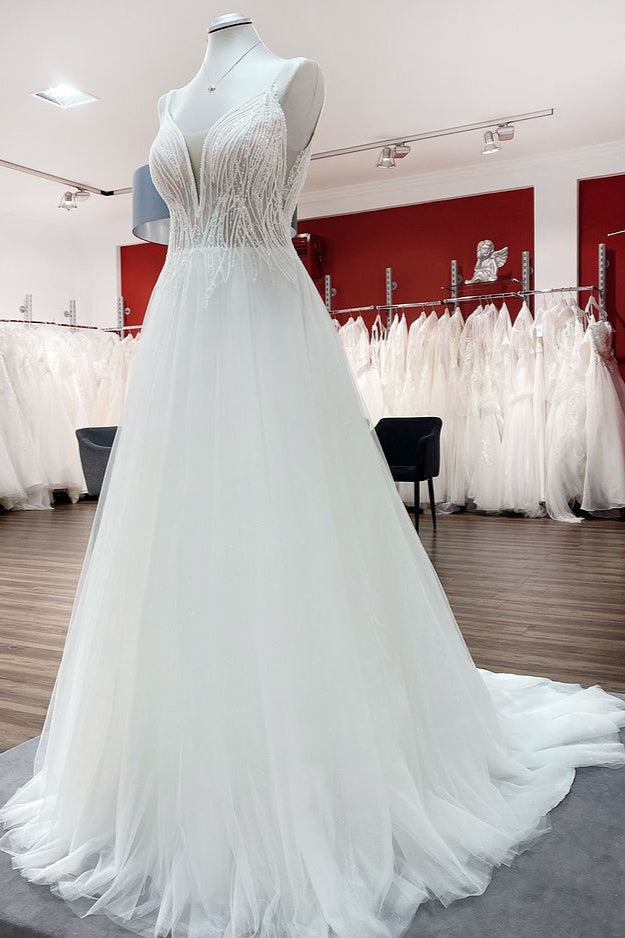 Vestido de novia sencillo de tul con escote en V largo, lentejuelas, volantes y espalda descubierta.