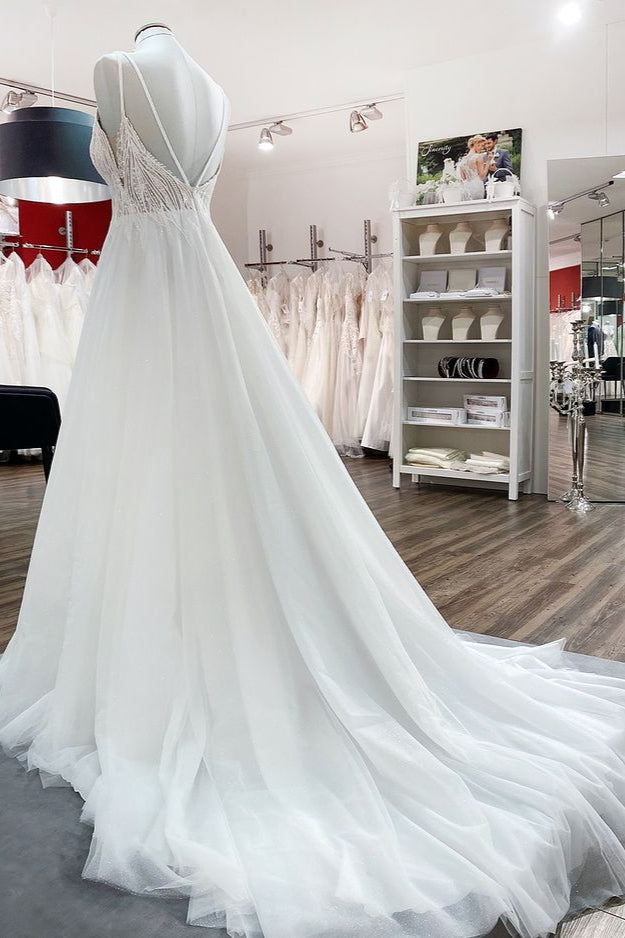 Vestido de novia sencillo de tul con escote en V largo, lentejuelas, volantes y espalda descubierta.