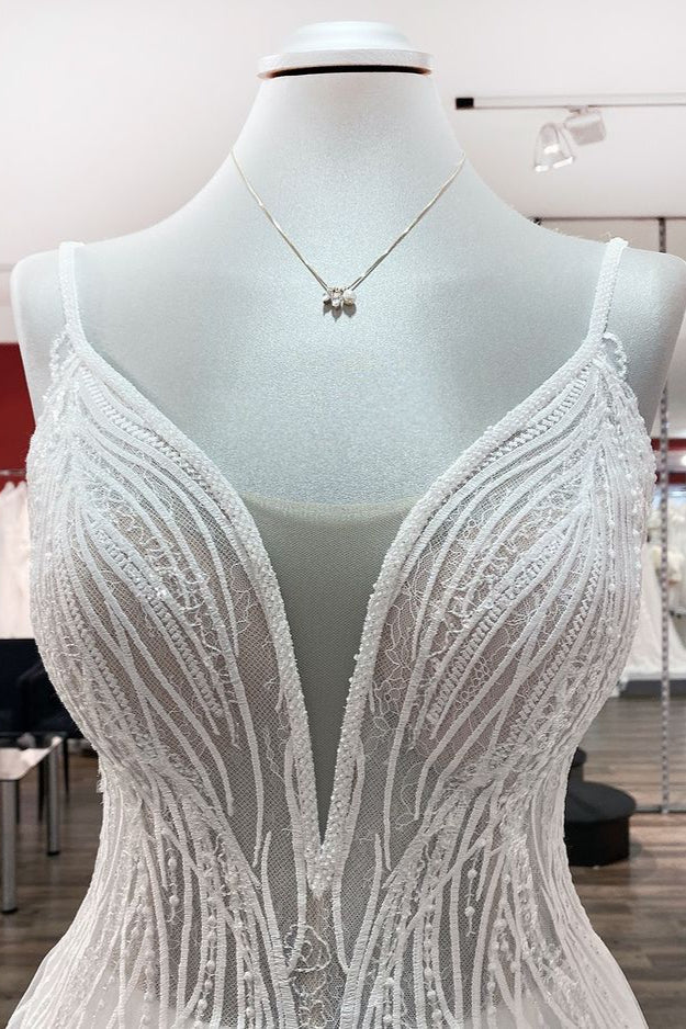 Vestido de novia sencillo de tul con escote en V largo, lentejuelas, volantes y espalda descubierta.