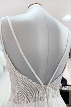 Vestido de novia sencillo de tul con escote en V largo, lentejuelas, volantes y espalda descubierta.