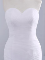 Vestido de novia de sirena sin tirantes con escote corazón y encaje de tul sin volantes.