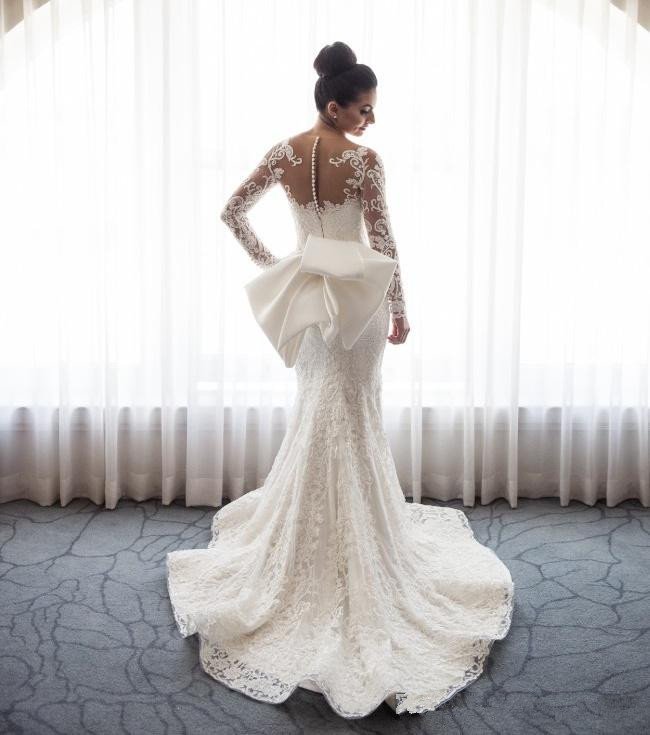 Impresionante vestido de novia de sirena con encaje y lazo, con falda desmontable y mangas largas.