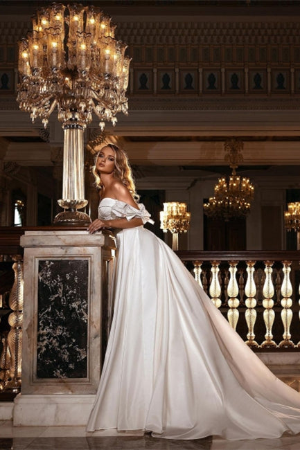 Impresionante vestido de novia blanco con hombros descubiertos, corte sirena, corte entallado, escote corazón, largo y cola desmontable.